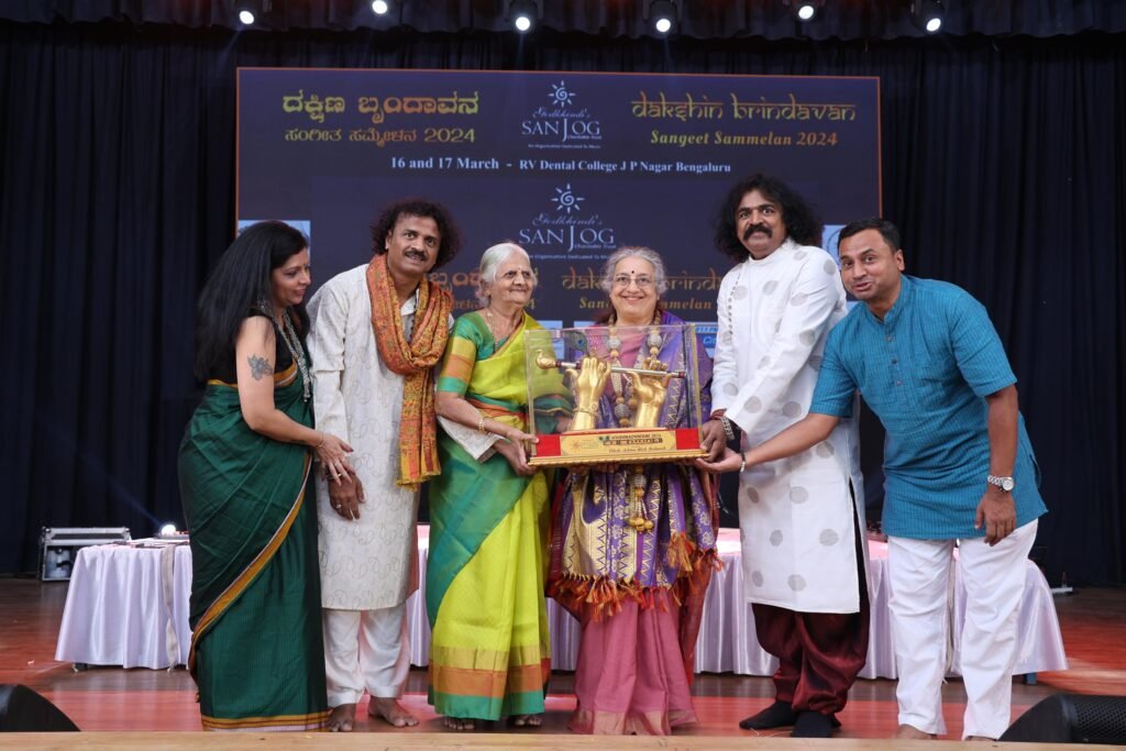 Students in white kurtas performing together on stage